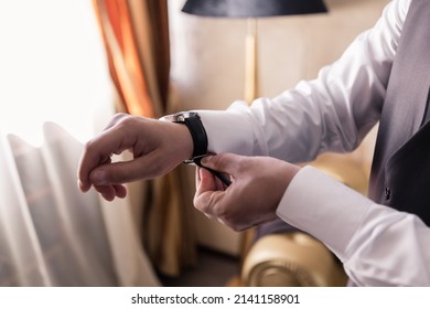 A Man Putting A Watch On His Hand