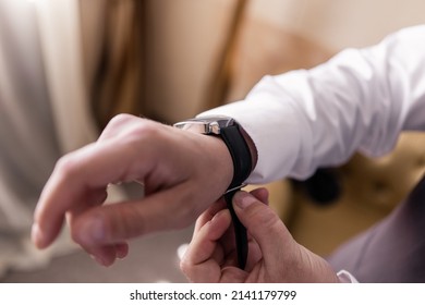 A Man Putting A Watch On His Hand