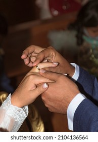 Man Putting Wedding Ring On Hand