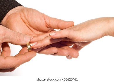man putting wedding ring on bride's finger