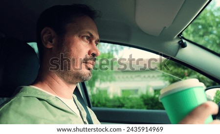 Man quenches thirst on car trip. Man driver drinks fast food drink inside car. Man drink tea, fast food coffee close-up in car. Concept fast food. Delicious food, drinks during family, business trip
