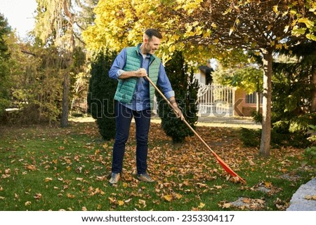 Image, Stock Photo Male gardener raking the the flower bed while the collegue is sweeping the terrace in summer