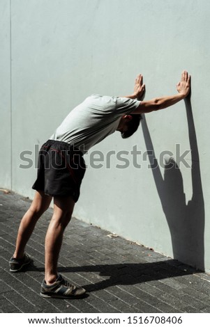 Similar – Athletic man warming up before running.