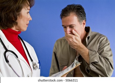 A man reacting with grave concern to news from a woman that appears to be his doctor.