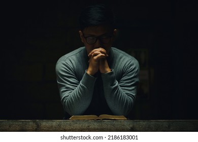 A man read the holy bible and prayers for the blessing of Christ. The atmosphere light from above represents a symbol of hope and salvation from the Lord . Christian life crisis prayer to god.
