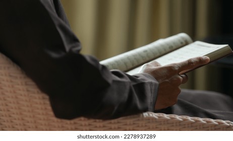 Man reading Al Quran on dark background Ramadan - Powered by Shutterstock