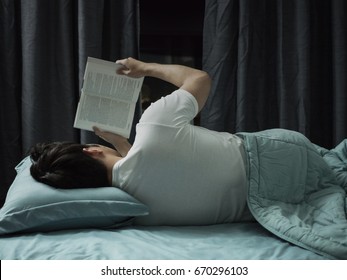 Man Reading Book In The Bed At Night