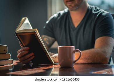 Man reading book with coffee in natural lighting  - Powered by Shutterstock