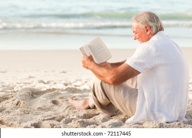 Man Reading A Book On The Beach