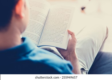 Man Reading Book While Sitting On The Couch - Soft Focus With Vintage Color Effect