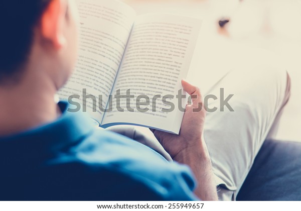 Man Reading Book While Sitting On The Couch Soft Focus With Vintage