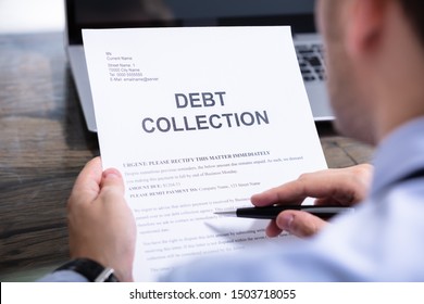 Man Reading Debt Collection Notice Letter At Desk