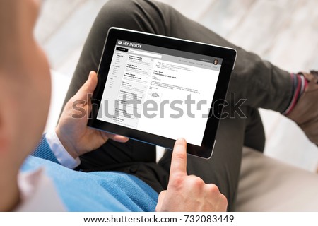 Man reading email on tablet. All content is made up.