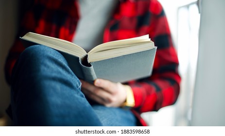 Man Reading An Interesting Book. Man Turning Pages Of Novel Enjoying Reading. Book Pages Close Up View.