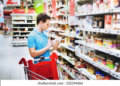 Man Reading Label On The Bottle In Supermarket