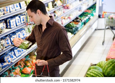 Man Reading The Label On Food Packaging In A Supermarket