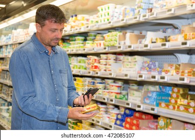 Man Reading Label On The Product In Supermarket