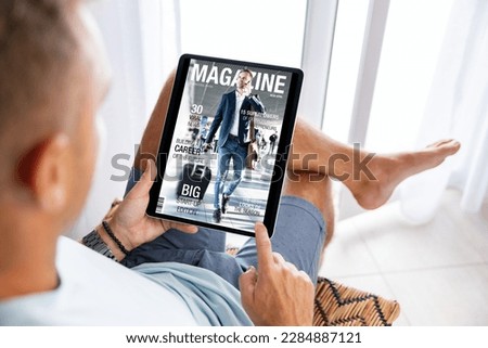Man reading magazine on tablet computer