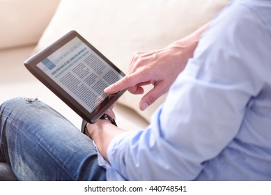 Man Reading News On Tablet