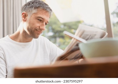 Man reading newspaper at breakfast - Powered by Shutterstock