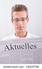 Man Reading Newspaper With The Headline Current News