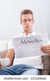 Man Reading Newspaper With The Headline Current News