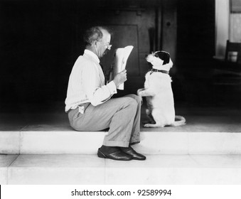 Man Reading A Newspaper With His Dog