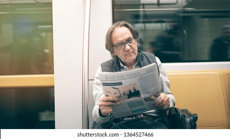 Man Reading Newspaper In The Metro Train