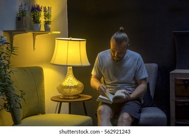 Man Reading At Night. Man Read A Book In Twilight. Horizontal Indoors Shot