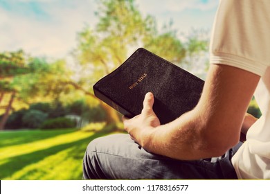 Man Reading Old Bible Book On Background