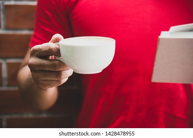 man reading an old book while enjoying the taste and the aroma of a coffee - Shutterstock ID 1428478955
