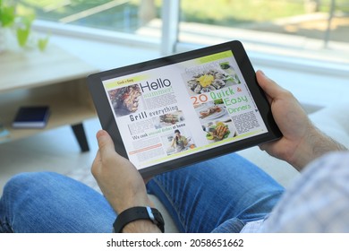Man Reading Online Magazine On Tablet Indoors, Closeup