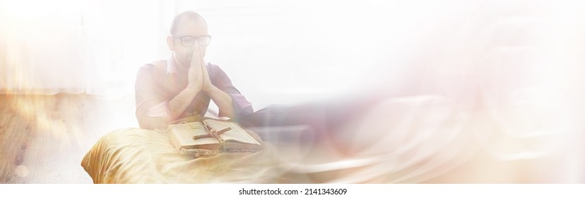 Man Reading And Pray From The Holy Bible Near The Bed In Evening. Christians And Bible Study Concept. Studying The Word Of God In Church.