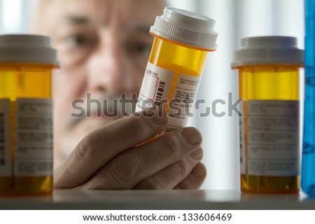 Man reading prescription bottle