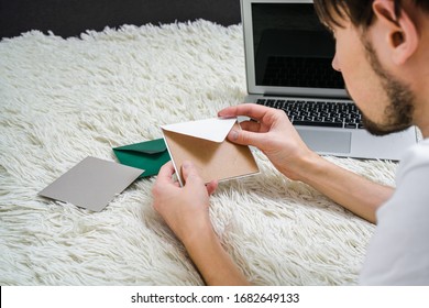 A Man Reads Letters While Lying On A Bed At A Laptop. Man Sends A Birthday Card