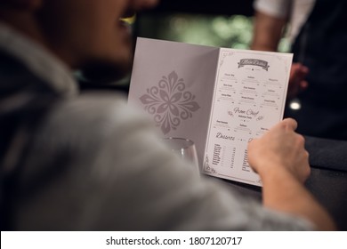 a man reads the menu in the bar, close-up of the menu and hands. - Shutterstock ID 1807120717