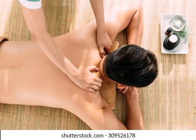 Man receiving relaxing back massage in the spa center