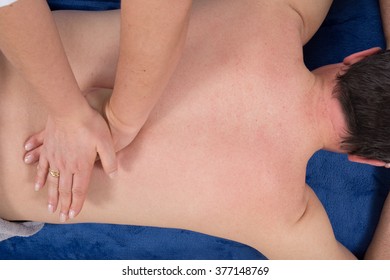 Man receiving relaxing back massage in the spa center