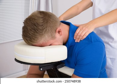 Man Receiving Shoulder Massage From Female Physiotherapist