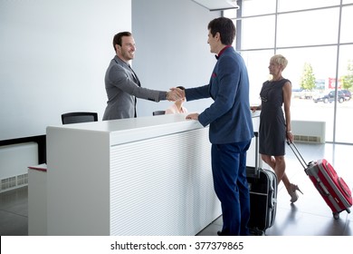 Man and receptionist handshake at reception hall 