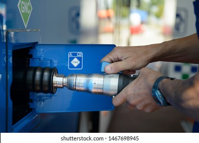 A man recharges a vehicle with compressed natural gas fuel, ecological fuel known as CNG