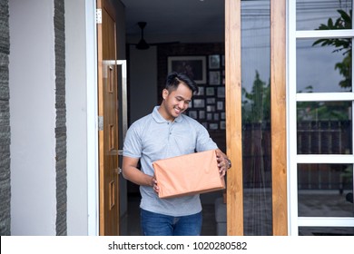 A Man Recieve A Delivery Box In Front Of His House Door