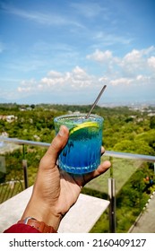 A Man Recording A Drink Called Blue Ocean Above A Cafe With A Stunning View