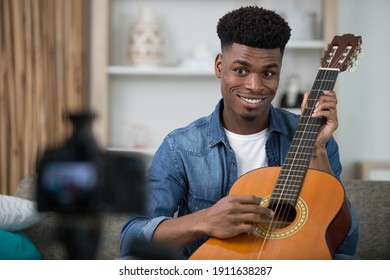 Man Recording A Guitar Performance On Camera