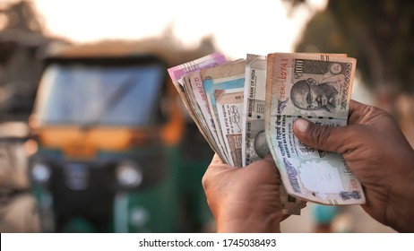 A Man Recounts Indian Rupee Money Amid Tuk Tuk.