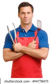 Man In Red Apron And Blue Polo Shirt With Barbecue Grilling Cooking Utensils Isolated On White Background