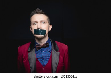 Man In Red Jacket With Closed Tape Over His Mouth. Black Isolated Background.