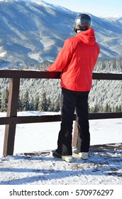 Man in red jacket looking at winter mountains, back view of man with copy space 