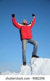 man in red jacket on top of snow hill