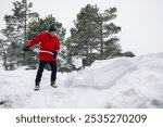 Man in red jacket working hard to shovel thick snow ,physical labor, snowfall aftermath, rural lifestyle, winter activity